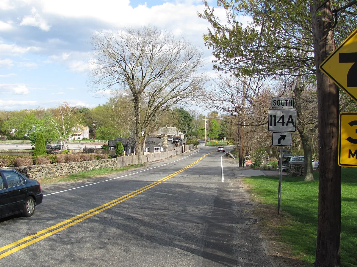 Route 114A running past stone walls and houses in Seekonk, Massachusetts